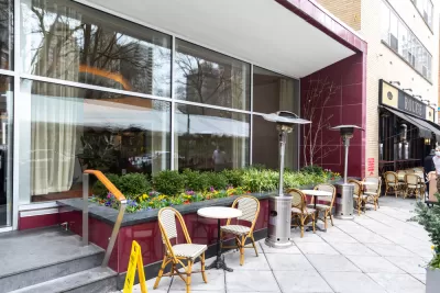 Empty chairs and tables on sidewalk at a Phialdelphia restaurant