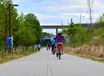 People on bikes ride along paved Atlanta BeltLine bike trail