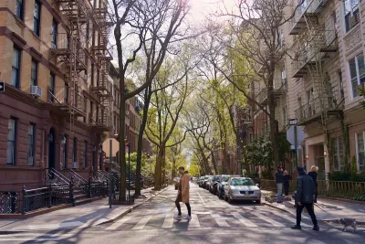 A person crossing the street between two residential buildings in NYC.