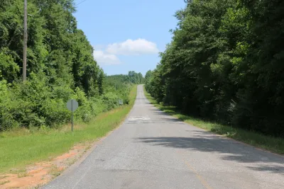 Empty two-lane rural road in Alabama with forest on both sides.