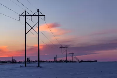 Power lines against sunset sky and snowy landscape in rural Minnesota