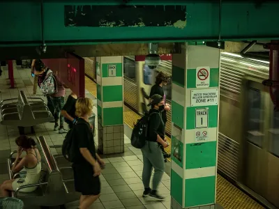 Crowded SEPTA subway station with people wearing masks waiting for train.