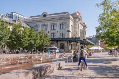 Cyclist paused in front of public water fountain in Denver, Colorado.