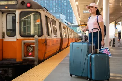 Orange Line platform with woman waiting with suitcases, Boston, Massachusetts