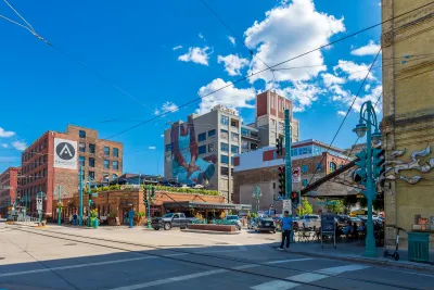 Intersection with murals on brick buildings and streetcar overhead wires in Milwaukee, Wisconsin on a sunny day.