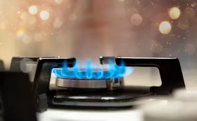 Close-up of lit burner on gas stove with blue flames