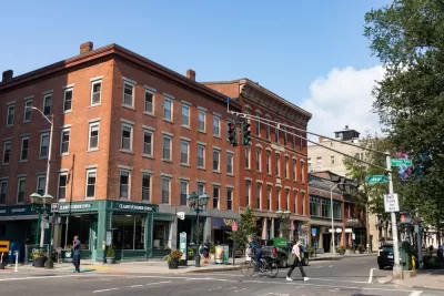Crosswalk with pedestrians in front of four-story red brick buildings in New Haven, Connecticut