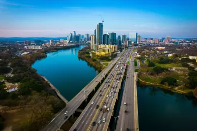 Aerial view of Interstate 35 bridge over river into downtown Austin, Texas with skyline in background