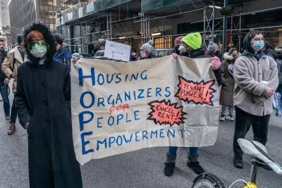 People wearing K95 masks holding a banner calling for renters' rights in a protest in New York City.