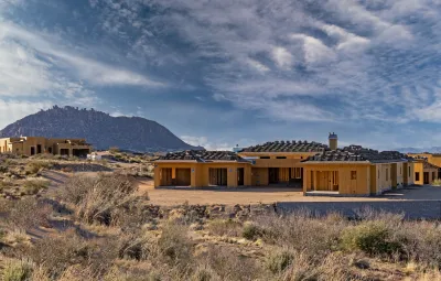 New wood-frame single-famly houses being built in Arizona with desert mountains in background.