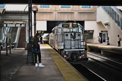 Silver NJ Transit train pulling into a station.