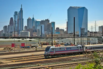 SEPTA train on track in front of Phildelphia city skyline.