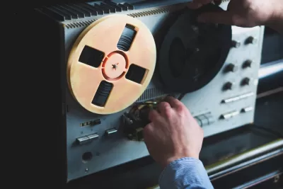 Close-up of reel-to-reel tape recorder with hand turning knob