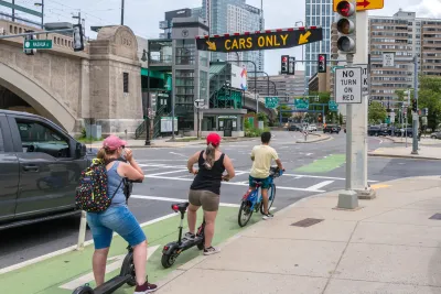 Two scooters and a bike ride in a bike lane in Boston