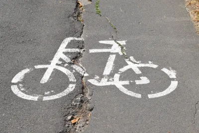 White bike logo on cracked asphalt.