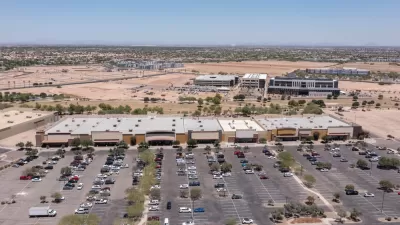 Aerial view of sprawling commercial development with parts still under construction and parking lot in Goodyear, Arizona