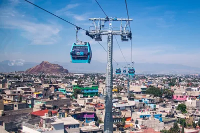 Blue aerial gondolas over colorful Mexico City neighborhood.