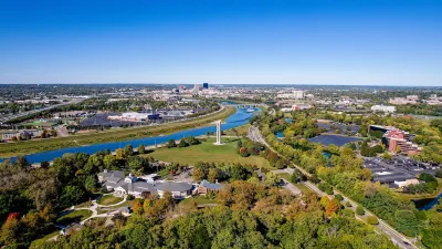 An aerial view of Dayton with a river and many trees visible