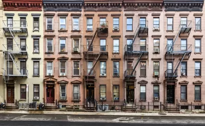 Multicolored four-story brick New York City apartment buildings with fire escapes