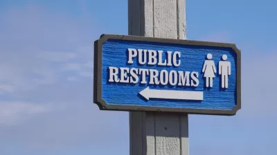 Blue "Public Restrooms" sign with arrow against a blue sky