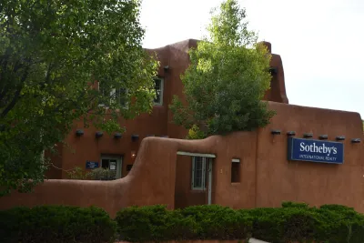 Adobe-style building in downtown Santa Fe, New Mexico with Sotheby's realty sign.