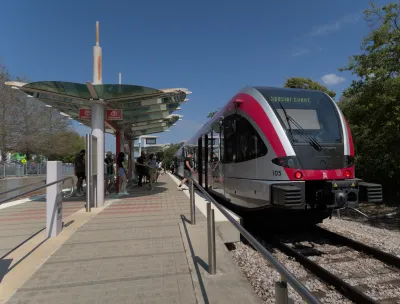 Red and silver light rail train pulling out of station in Austin, Texas.