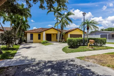 Yellow one-story house on residential street in Miami, Florida.