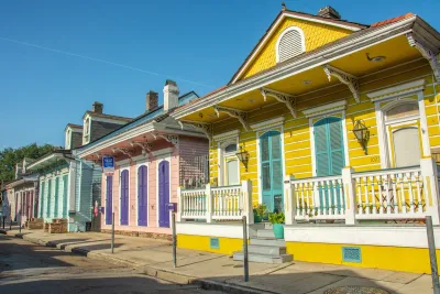 Bright yellow, pink, and green historic wooden houses in New Orleans, Louisiana.