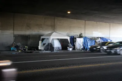 Encampment of tents and camopies built by unhoused people in freeway underpass in Venice, California.