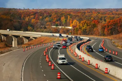 Cars driving on Ohio freeway with orange cones blocking off one lane.