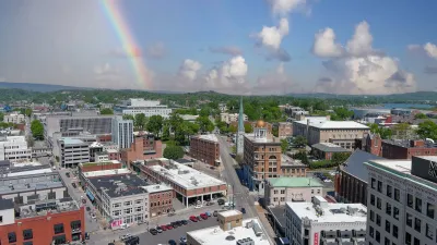 Aerial of Chattanooga, Tennessee with gold dome visible in center and a rainbow in the sunny sky.