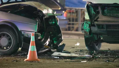 Two cars with smashed fronts stopped in street after crash.