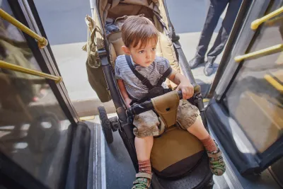 Boy in stroller being pushed onto bus.
