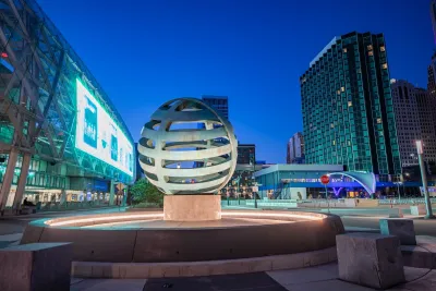 Spherical sculpture lit from underneath in front of convention center in downtown Detroit, Michigan.