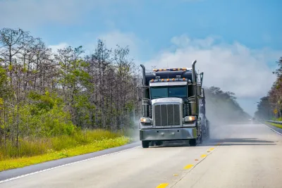 Big rig truck driving alone down two-lane Florida highway.