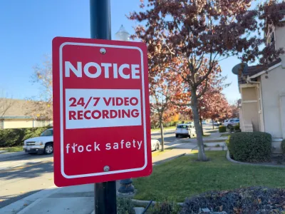 Red and white sign on post with "Notice: 24/7 video recording - Flock Safety" text.