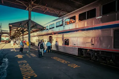 People on train platform next to silver Amtrak train in Portland, Oregon.