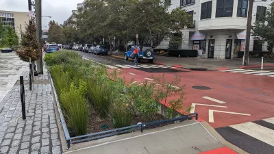 Street in Hoboken, New Jersey with red painted bus lane and landscaped bioswale next to curb.
