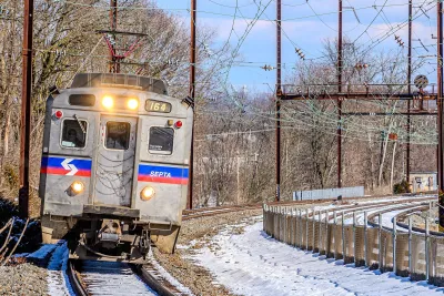 A silver SEPTA train passing through snowy scenery in Pennsylvania.