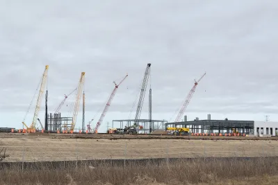 Large building for Microsoft data center under construction with cranes and heavy equipment in flat treeless field in Mt. Pleasant, Wisconsin.