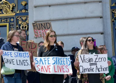 Traffic safety advocates holding signs calling for Vision Zero on steps of government building in San Francisco.