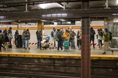 Crowd of people waiting on an NYC subway platform.