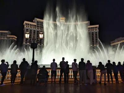 A crowd of people gather to watch the famous water fountain show in front of the Bellagio hotel in Las Vegas.