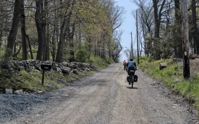 Two people on loaded touring bicycles on gravel Albany Post Old Trail.