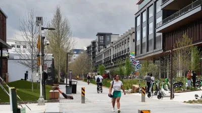 People walking on Atlanta Beltline paved walking and biking trail next to mid-rise buildings.
