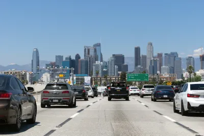 Traffic on a freeway heading into downtown Los Angeles on a sunny day.