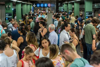 A crowded subway platform in NYC on a hot day