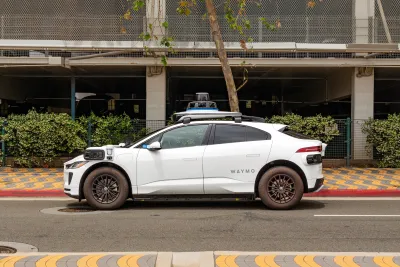 White Waymo robotaxi parked next to red curb in Santa Monica, California.