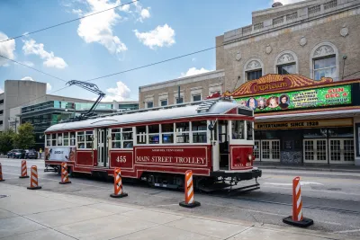Red vintage-style Memphis trolley on street in front of old-style theater marquee.