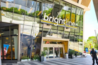 The outside of a brightline transit hub with many windows on a sunny day.